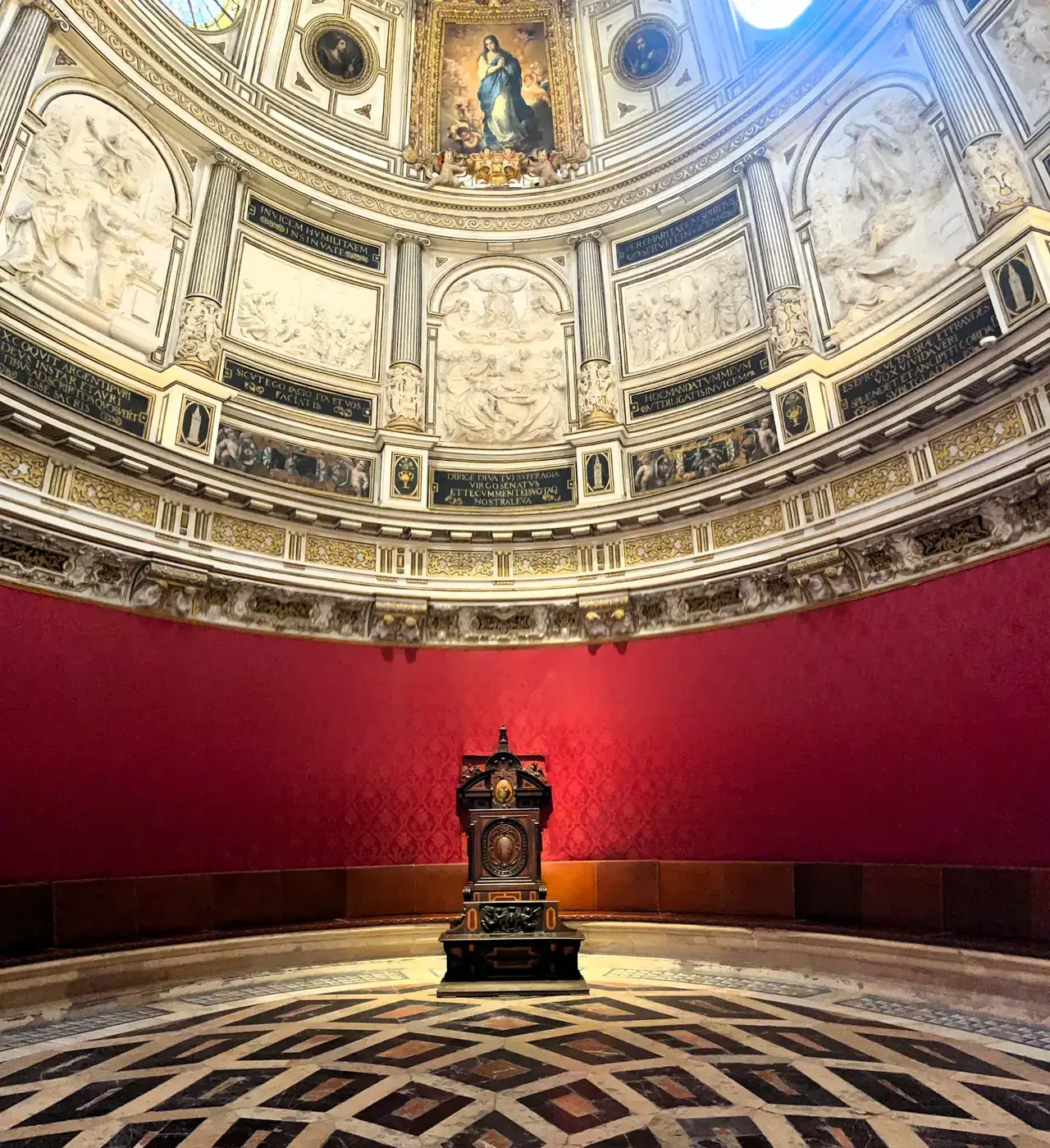 Elliptical domed chapterhouse of Seville Cathedral with Murillo's Immaculate Conception above the archbishop's throne
