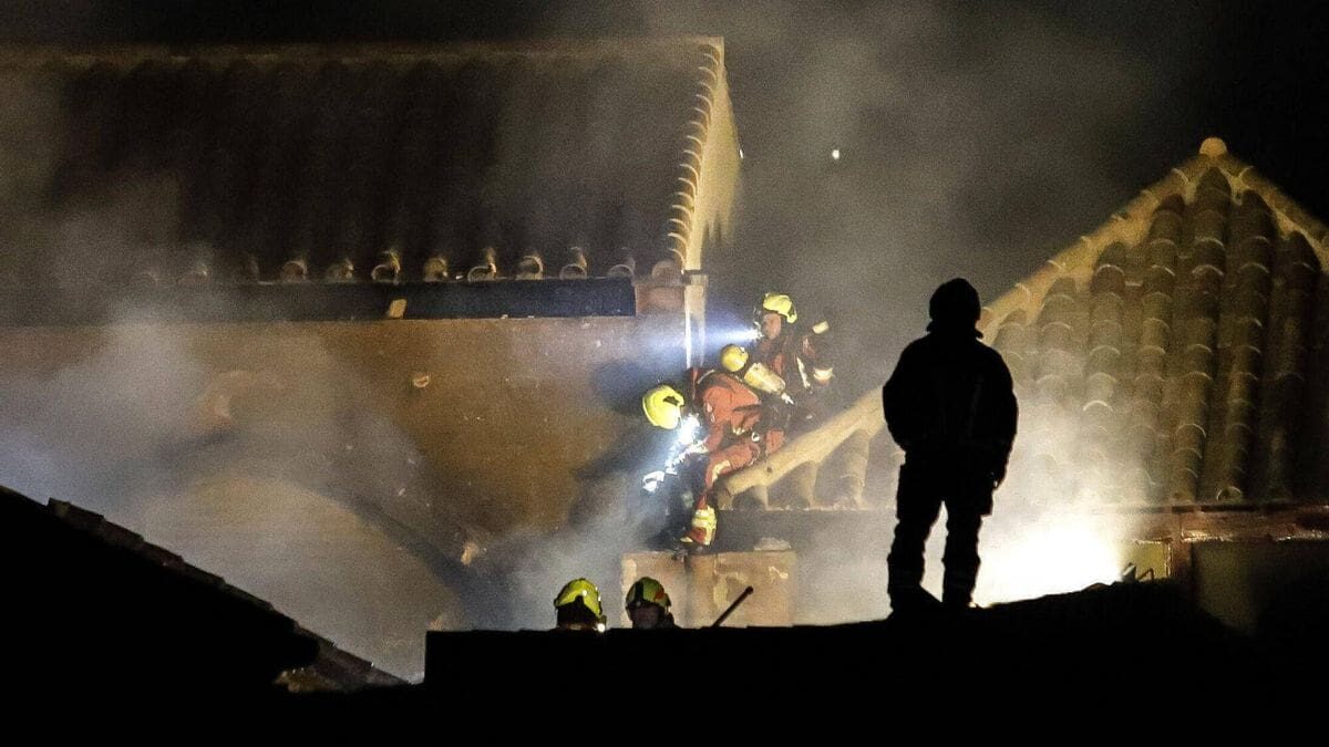 Firefighters working at night on the roof of the Mosque-Cathedral of Córdoba after the fire