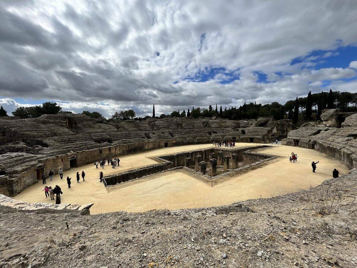 Visitors exploring the Roman amphitheater of Itálica near Seville